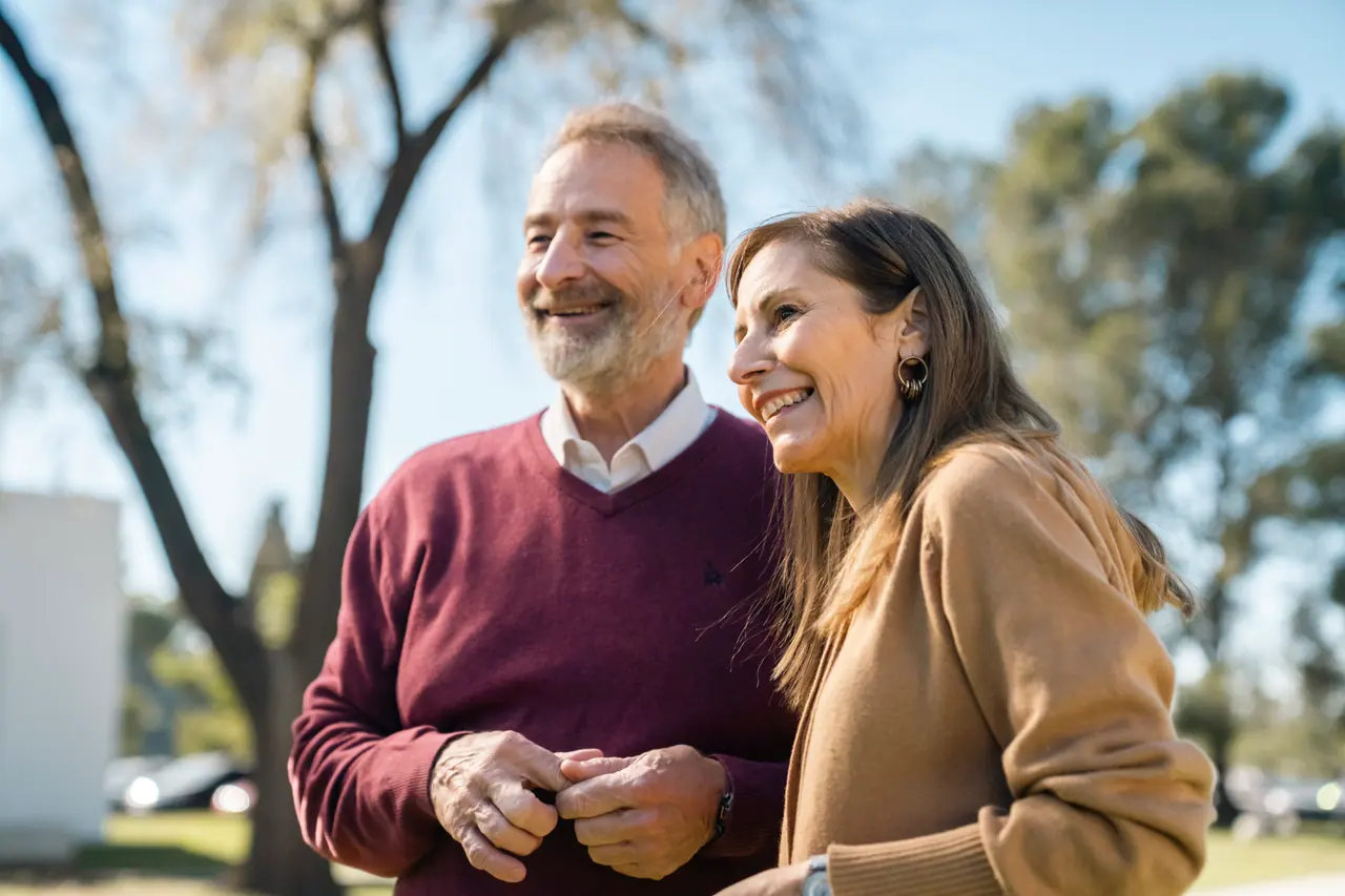 Una pareja sonríe al aire libre en un día de sol